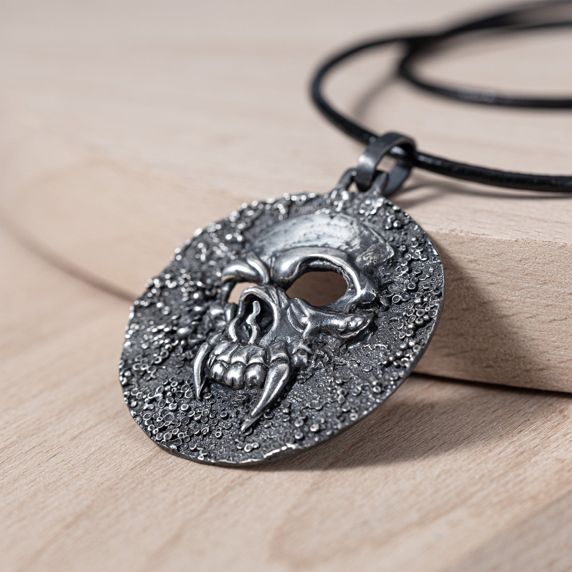 Helm Oxidized Silver Skull Pendant on Dark Textured Surface